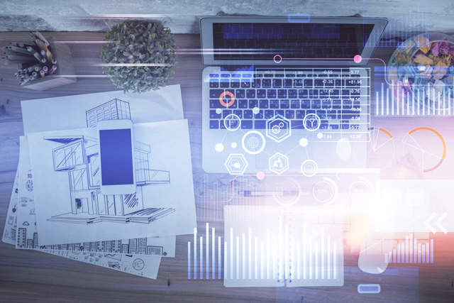 Auf einem Tisch liegen Baupläne und Skizzen sowie ein Laptop. Das Bild steht für die Antragstellung bei der digitalen Baugenehmigung.